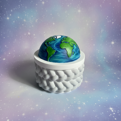 Painted Earth half-globe trinket box with light grey rope-twist base on soft lilac starry space background