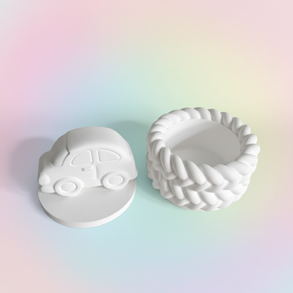 White plaster car trinket box lid off showing inside storage on pastel pink blue and lemon background