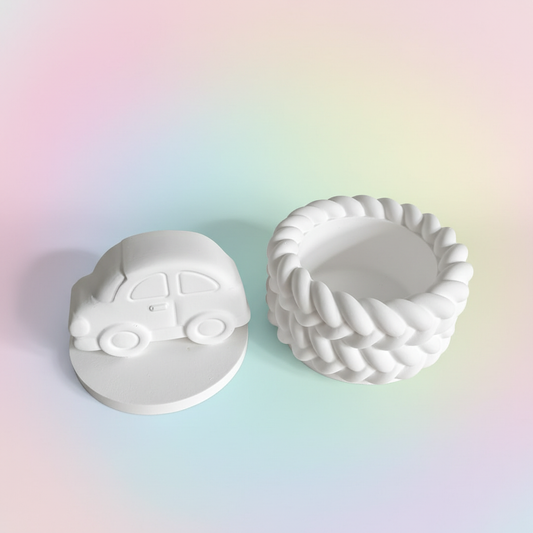 White plaster car trinket box lid off showing inside storage on pastel pink blue and lemon background